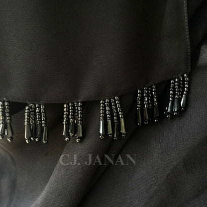 Black fabric with beaded fringe detail, featuring the brand 'C.J. Janan'.